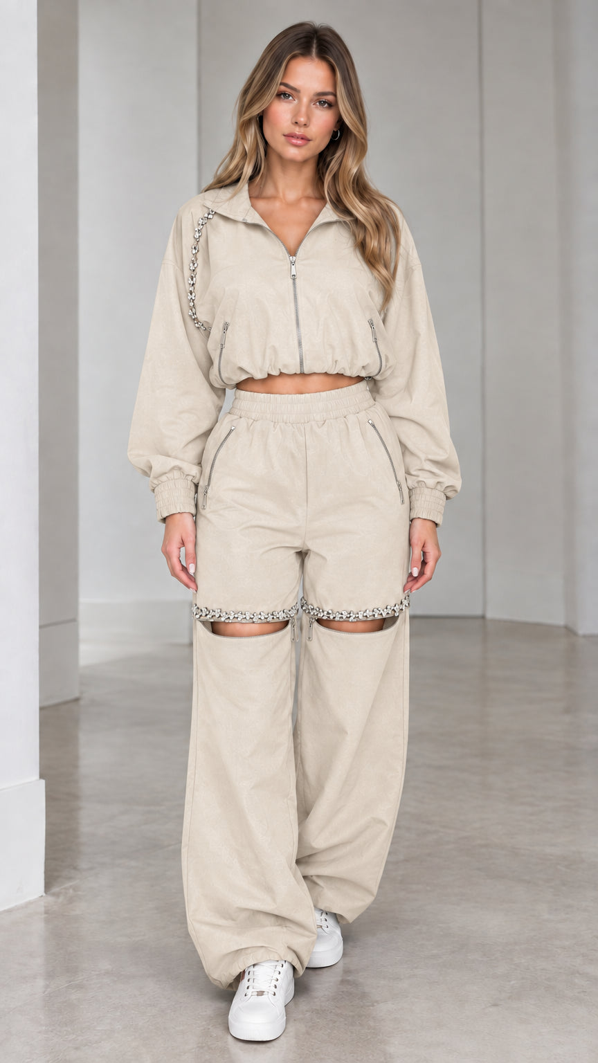Model wearing beige cream cropped zip jacket and rhinestone cut-out wide leg pants set