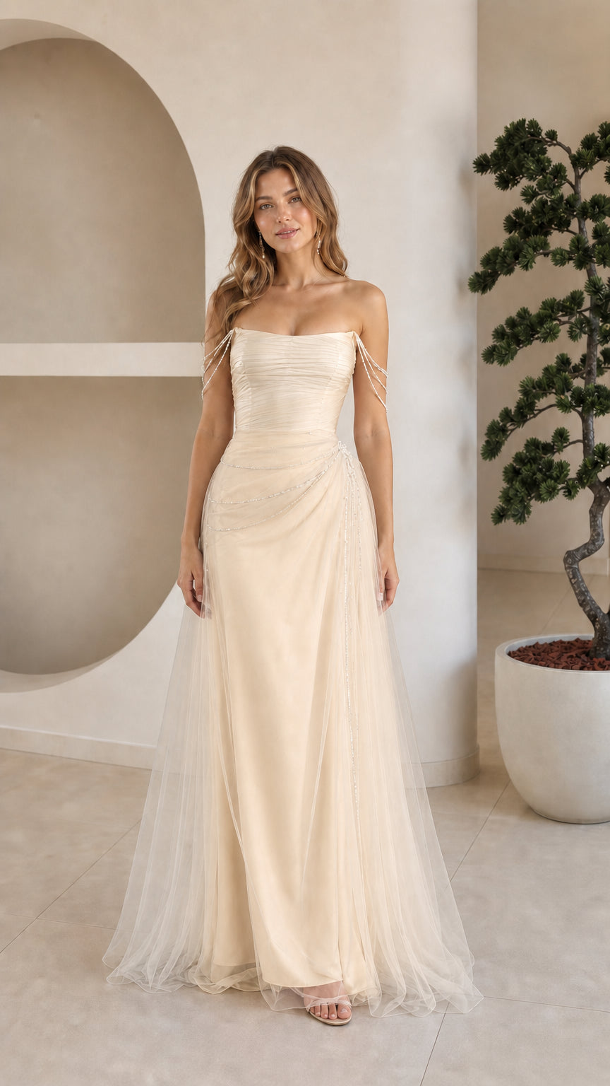 Front view of model in champagne cream strapless beaded tulle formal gown