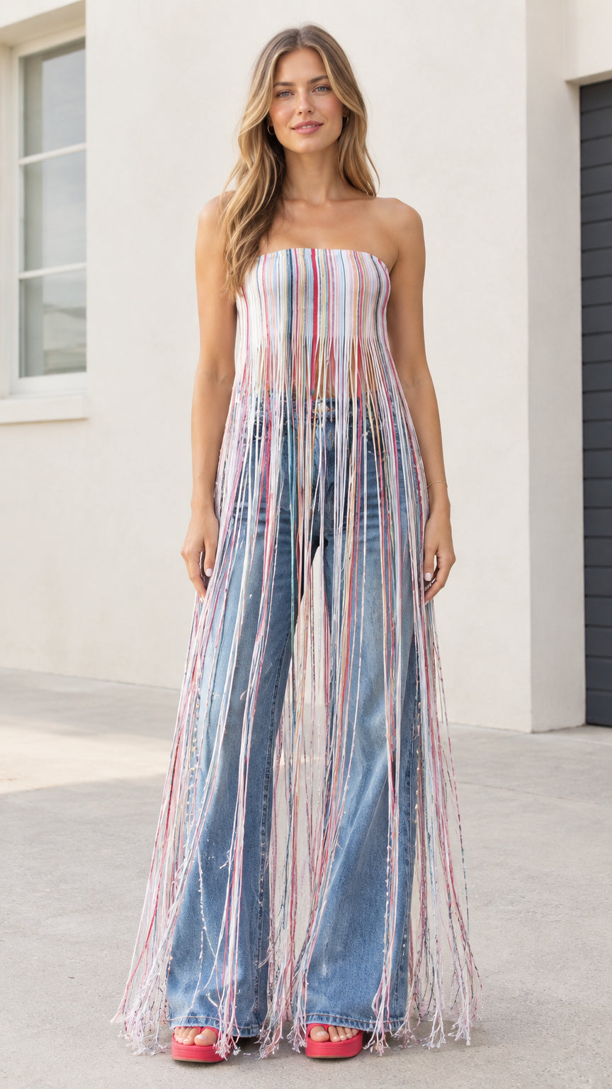 Model wearing multi-color blue strapless striped maxi fringe tube top with wide-leg jeans front view