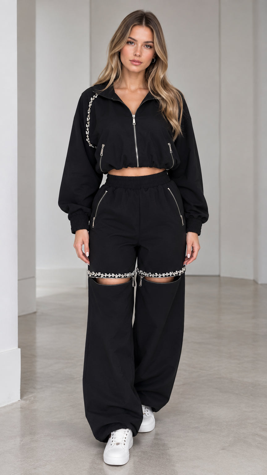 Front view of model wearing black rhinestone embellished cropped jacket and cut-out wide leg pants set