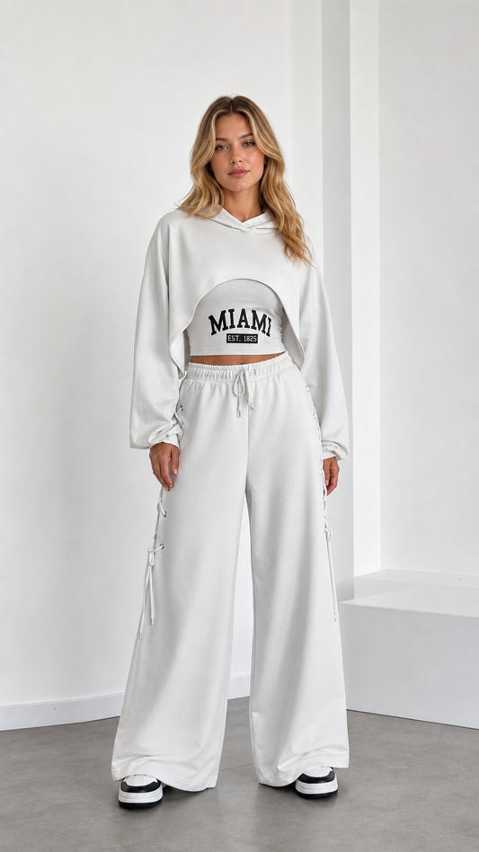 Front view of model wearing white 3-piece crop hoodie and wide leg sweatpants set
