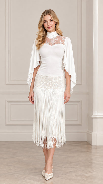 Front view of model wearing white mock neck illusion lace fringe midi dress with cape sleeves