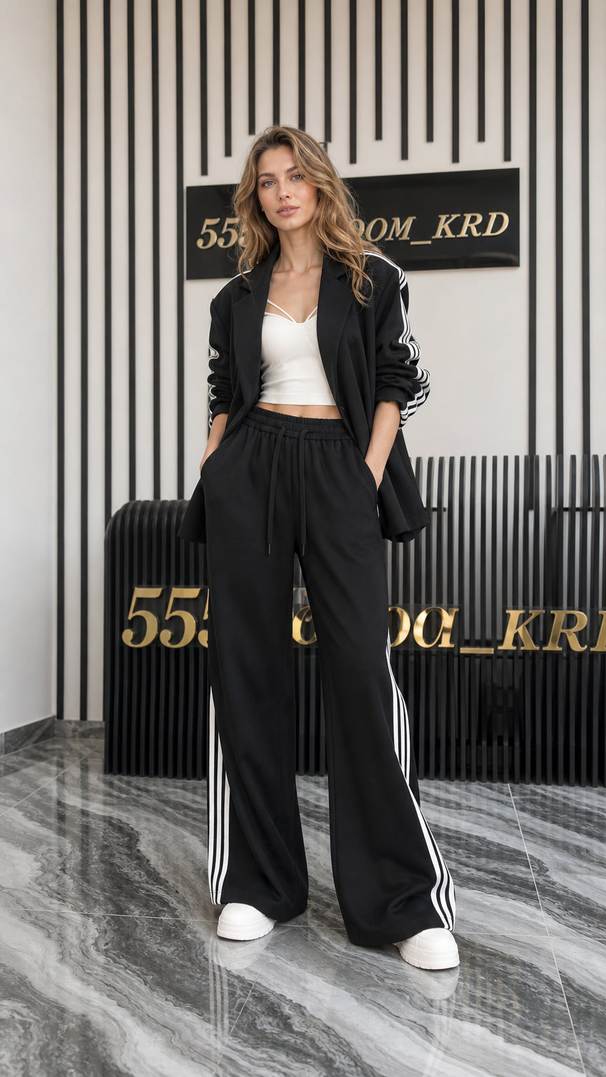Full front view of women's black 2-piece blazer and wide-leg track pant set with side stripes