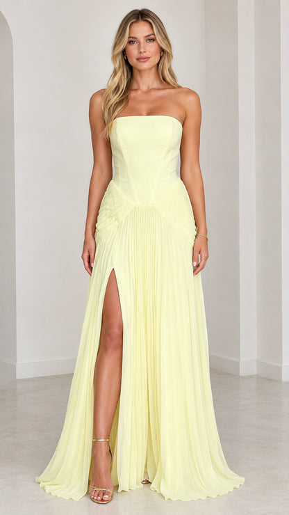 Front view of strapless light yellow pleated maxi gown with high slit