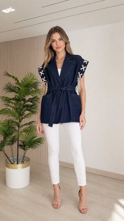 Front view of model wearing a Dark Blue sleeveless denim vest with lace-up shoulder detail and waist belt