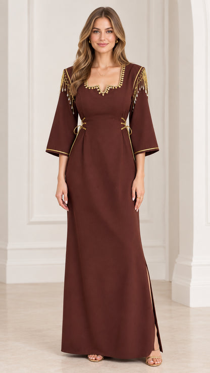 Front full view of woman wearing brown maxi dress with gold trim and beaded shoulder fringe