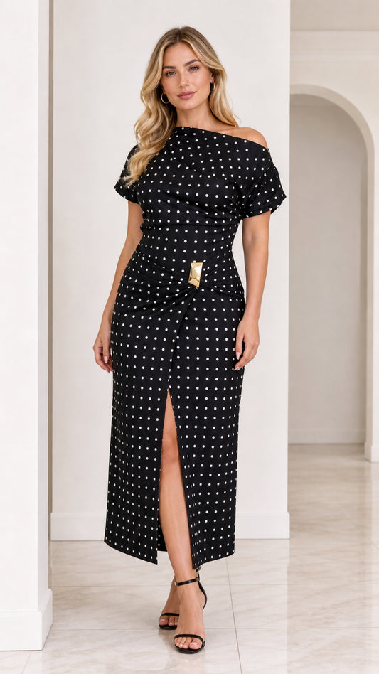 Front view of model wearing black polka dot asymmetrical midi dress with front slit