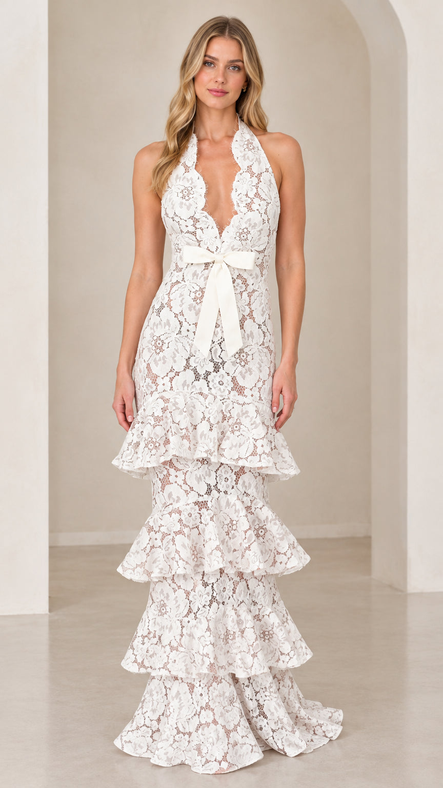 Front view of model wearing White halter neck tiered floral lace maxi dress with waist bow
