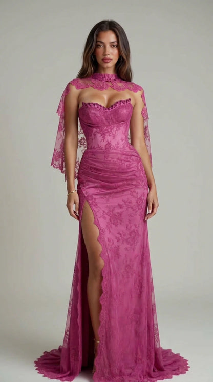 Front view of model wearing magenta lace corset evening gown with sheer capelet and high slit