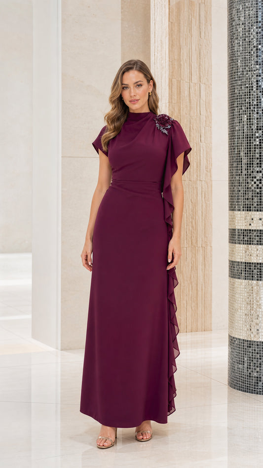 Front full-length view of woman wearing burgundy floral appliqué mock neck maxi dress with cascade ruffle