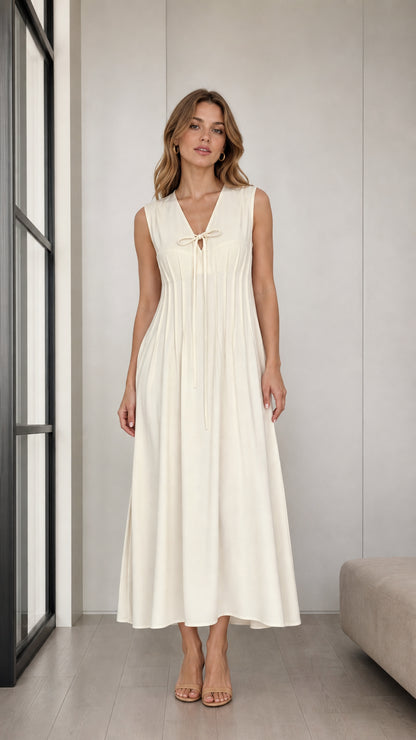 Front full view of woman wearing Cream sleeveless pleated midi dress with tie V-neck