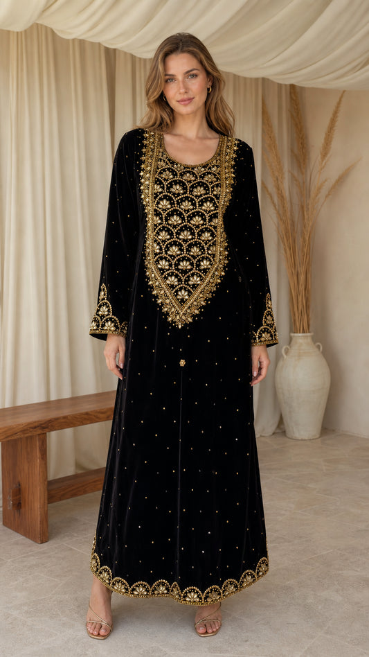 Model wearing black embroidered velvet maxi kaftan dress with gold beadwork - front view