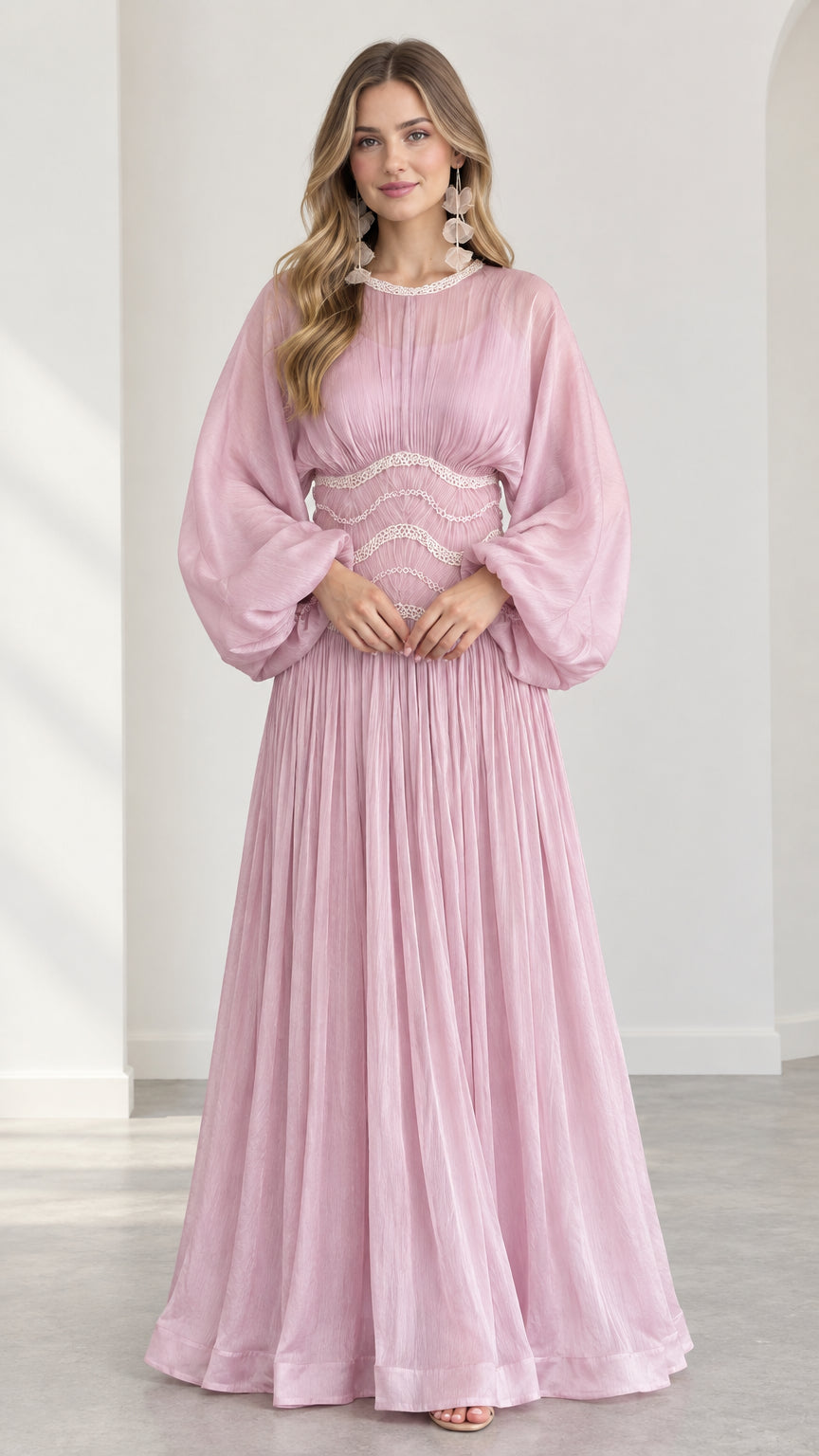 Front view of model wearing pink pleated maxi dress with balloon sleeves and embroidered waist