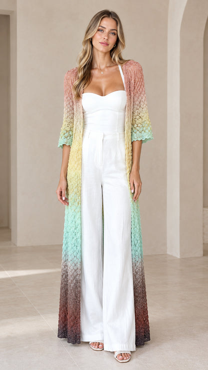 Front view of woman wearing Pastel Multi gradient crochet maxi duster cardigan over a white jumpsuit