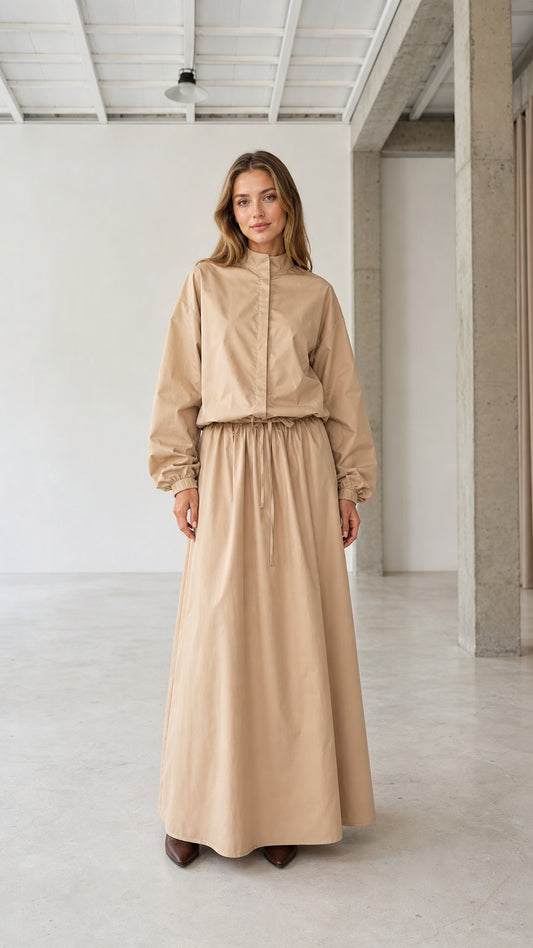 Front full view of woman wearing beige stand collar long sleeve drawstring maxi dress