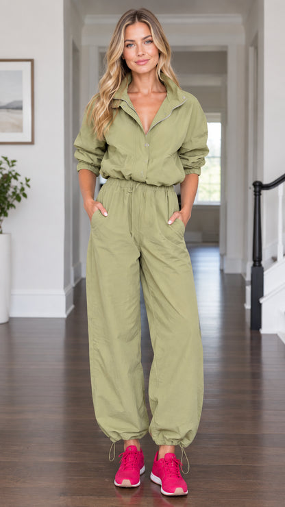 Front view of model wearing olive green utility parachute jumpsuit with drawstring waist