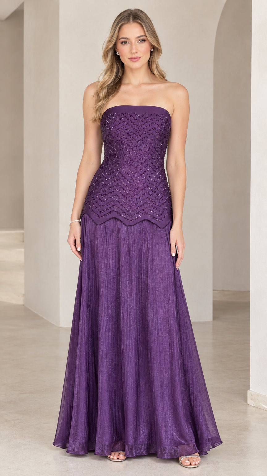 Front view of woman wearing purple strapless beaded drop-waist evening maxi gown
