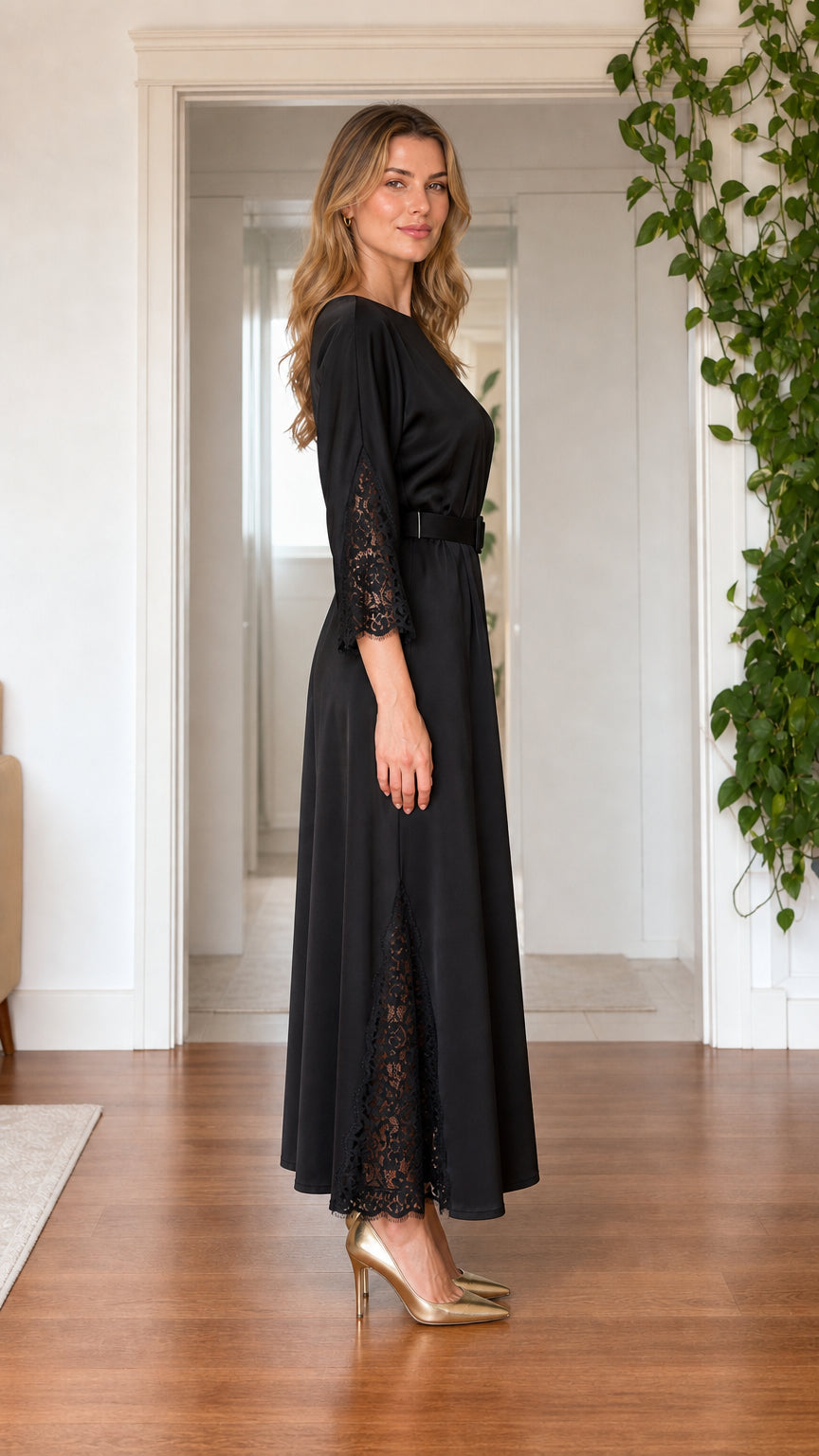Side view of model wearing black satin maxi dress showing lace sleeve and skirt detail