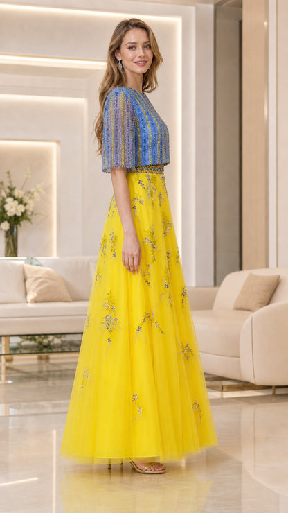Side-angle view of model in yellow and blue flutter-sleeve embellished maxi dress