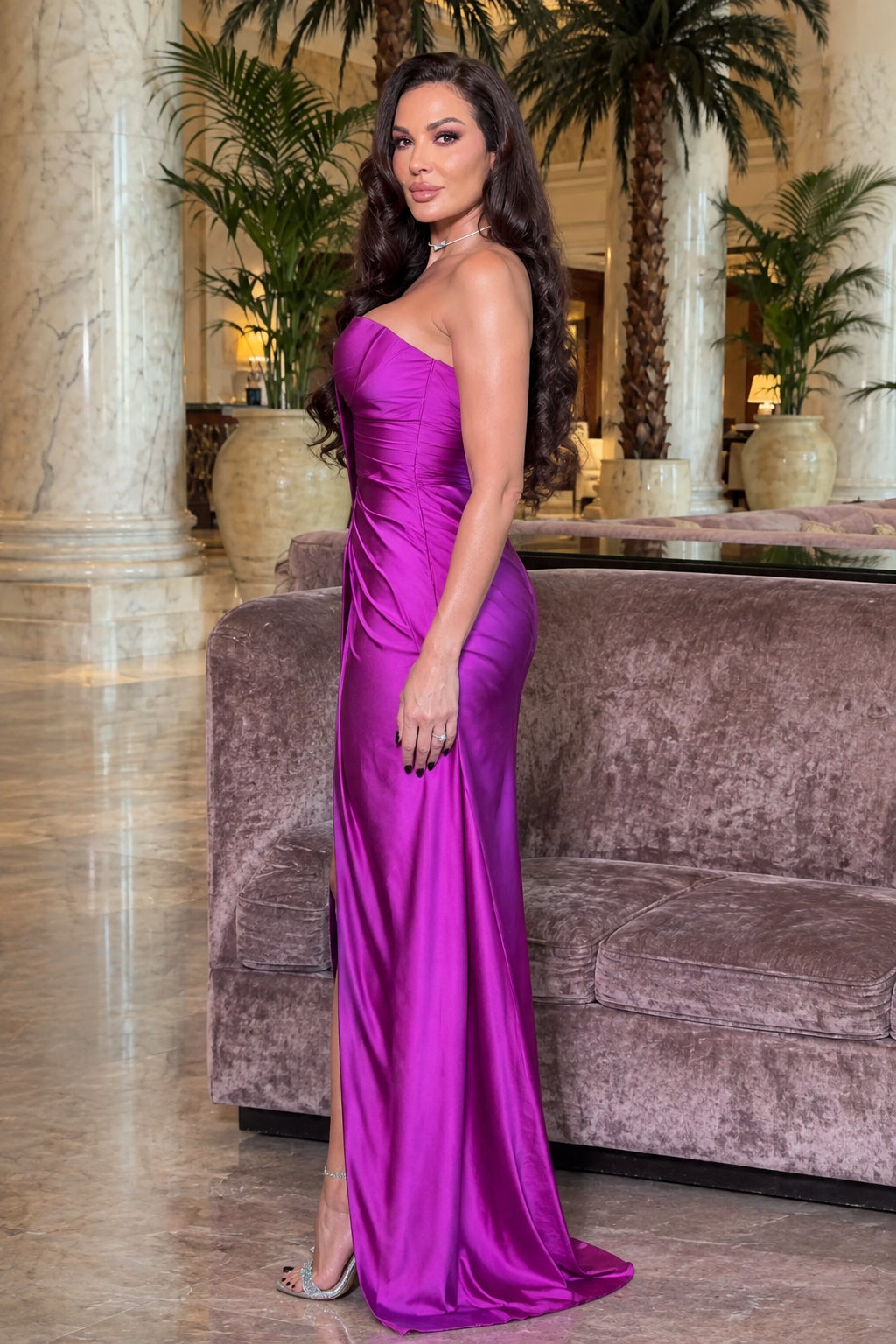 Model standing in a vibrant magenta strapless formal satin gown
