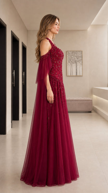 Side view of burgundy cold-shoulder embellished formal gown with tulle skirt
