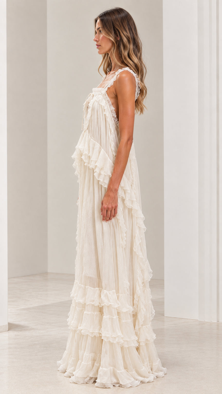 Side angle of woman in flowy ivory bohemian tiered maxi dress