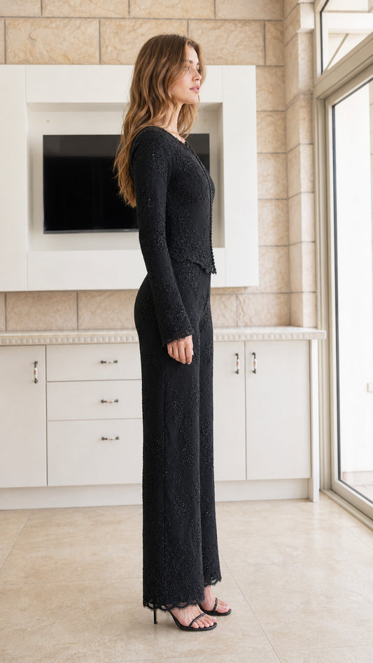 Side profile view of woman wearing black long-sleeve lace top and matching wide-leg pants