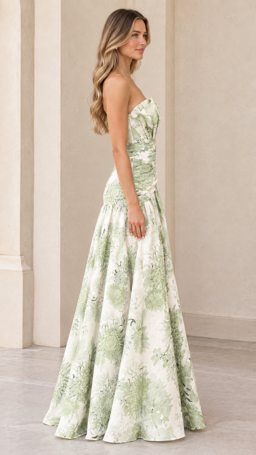 Side profile view of model in sage green floral strapless maxi dress