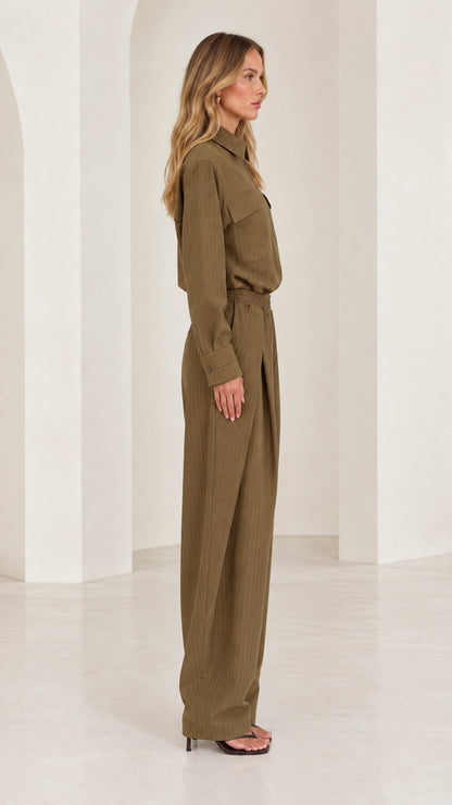 Side full-length view of woman wearing olive green tailored wide-leg jumpsuit