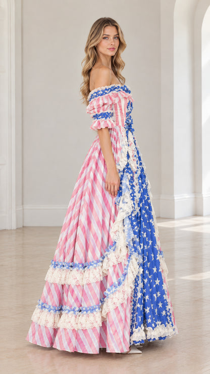 Side profile of model in pink and blue patriotic tiered ruffle maxi gown
