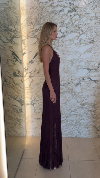 Side profile of model in burgundy halter fringe maxi gown