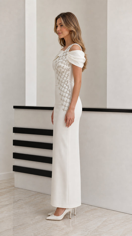 Side profile view of model wearing white off-the-shoulder embellished formal evening dress