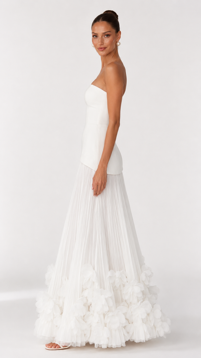 Side view of ivory strapless maxi dress with fitted bodice and full pleated skirt