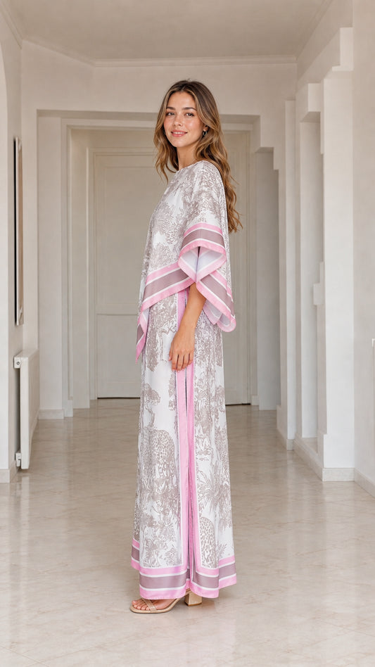 Side profile view of model wearing draped white animal print two-piece resort pant set