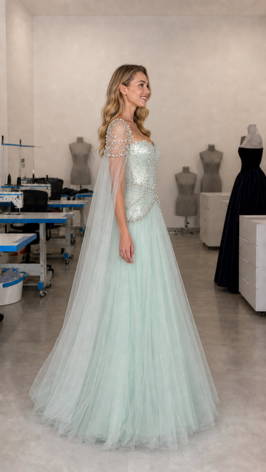 Side profile view of mint green embellished evening gown with flowing tulle skirt