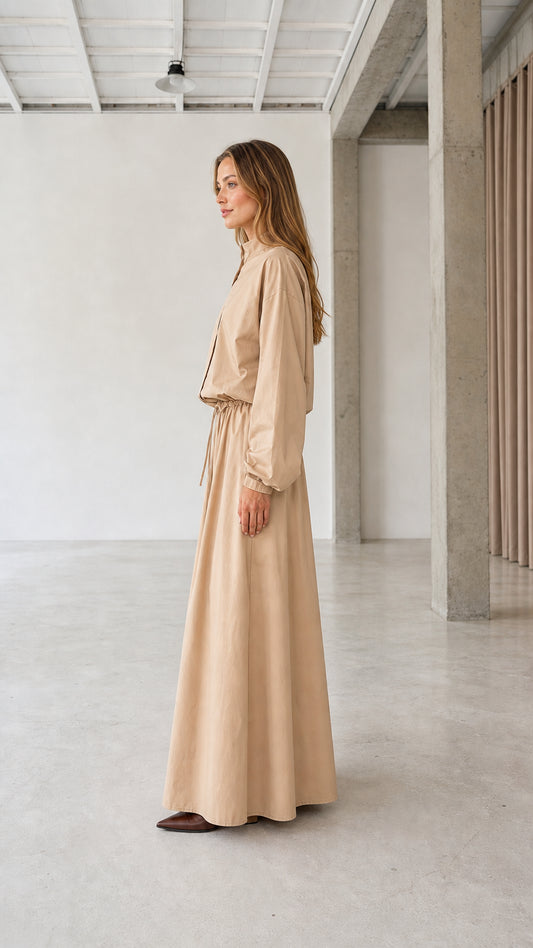 Side profile view of woman modeling beige long sleeve maxi dress