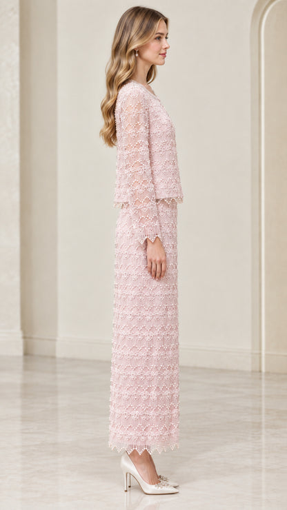 Side profile view of woman wearing blush pink beaded jacket and maxi column skirt