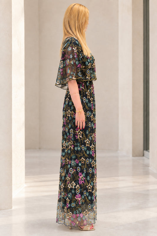 Side profile view of black sequin embroidered capelet evening gown