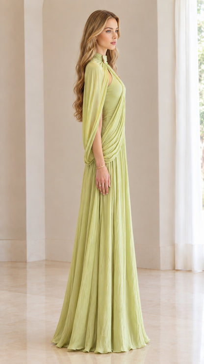 Side profile of woman wearing sage green pleated high-neck cape evening dress