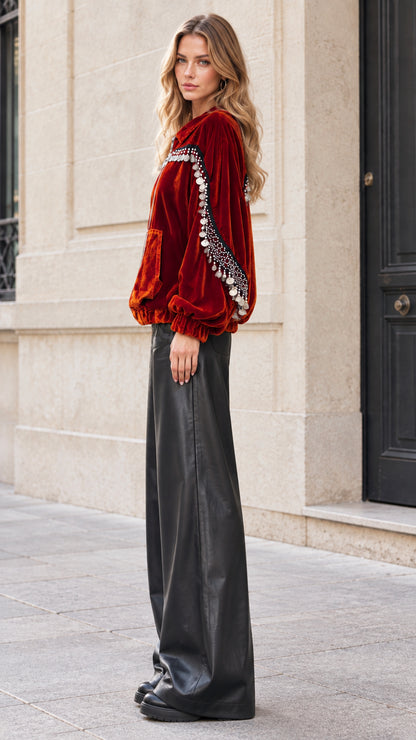 Side profile of model in rust velvet bomber jacket with sleeve coin detailing