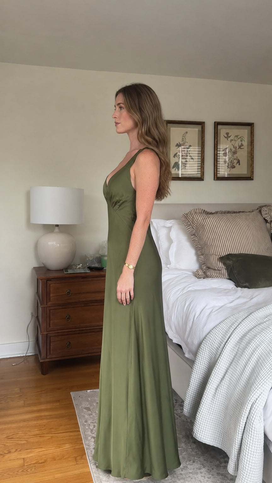 Side profile of olive green satin maxi slip dress showing flowing drape