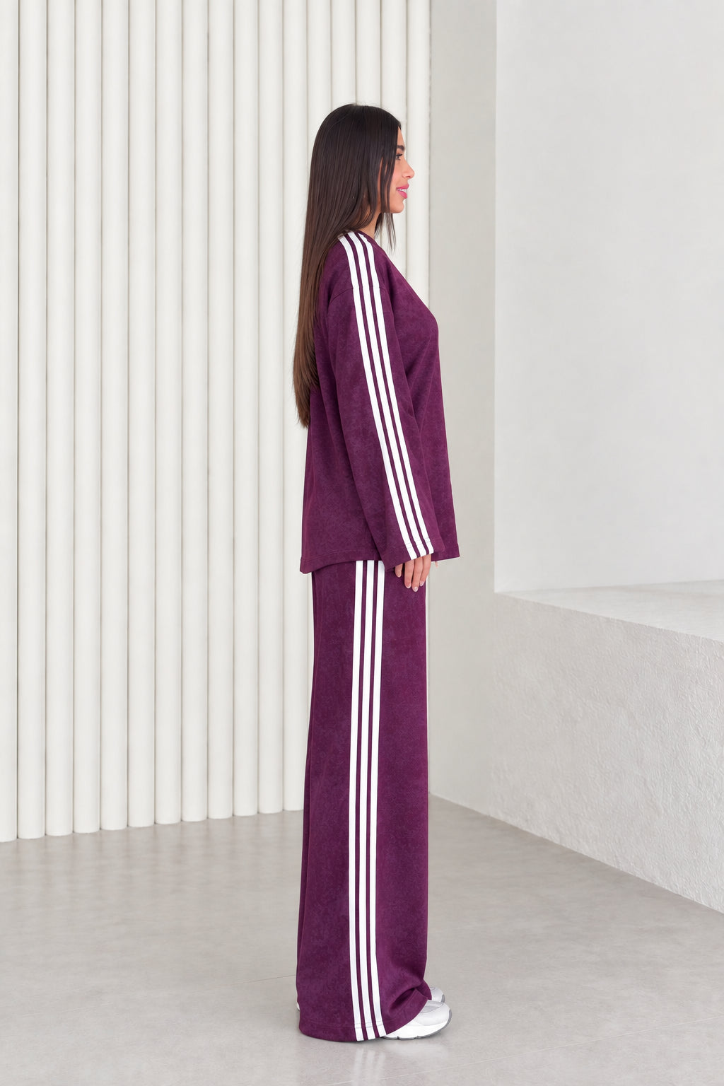 Side profile view of plum matching tracksuit set showing white side stripe details