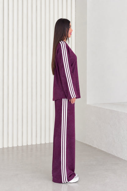 Side profile view of plum matching tracksuit set showing white side stripe details