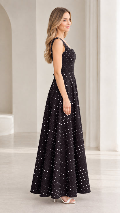 Side profile of model in black polka dot A-line maxi dress