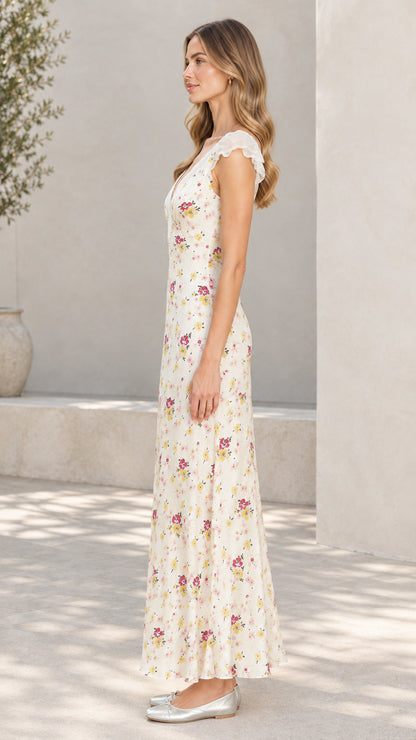 Side profile of woman wearing cream floral flutter sleeve maxi dress