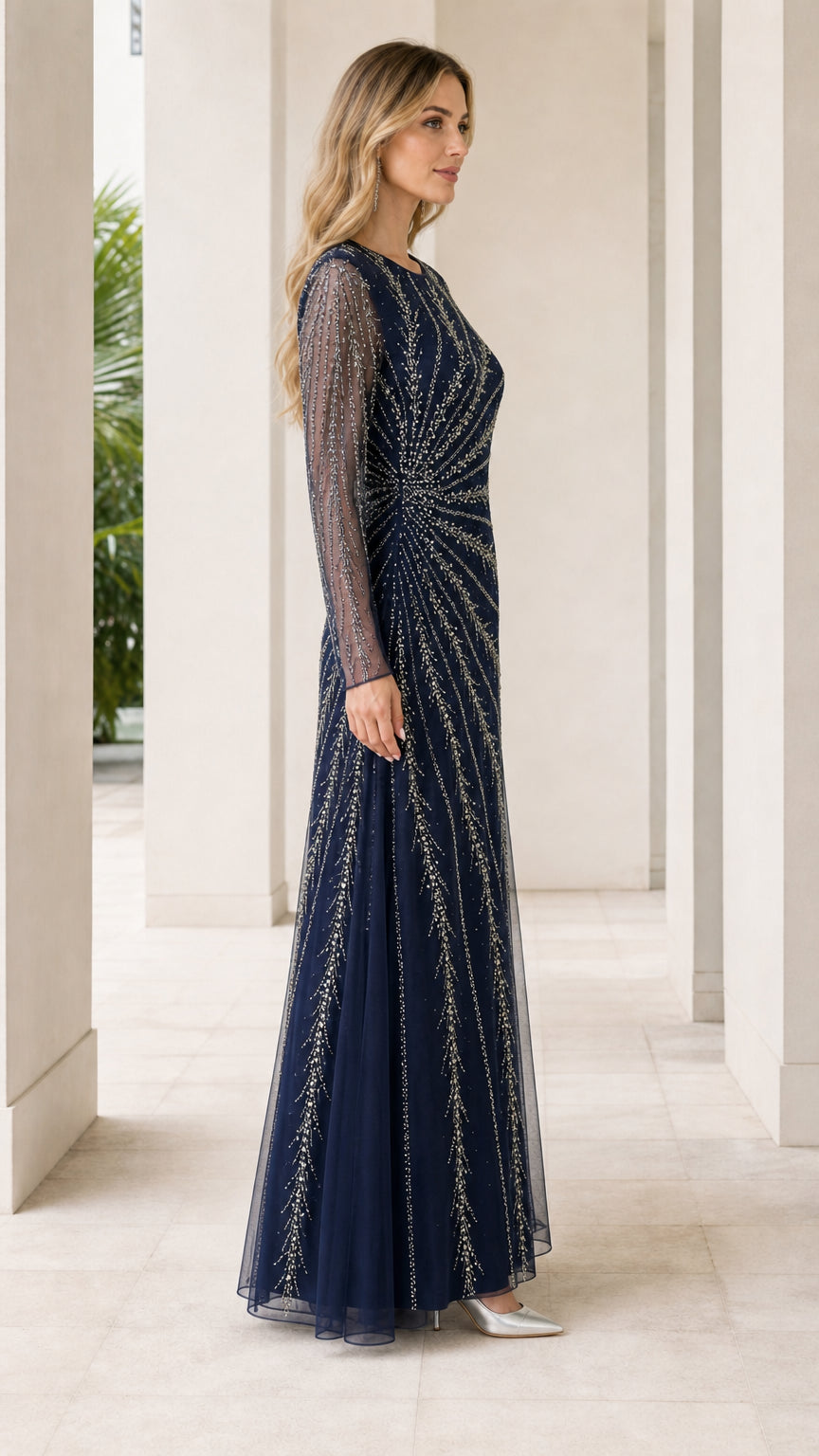 Side view of woman in navy blue floor-length embellished evening dress