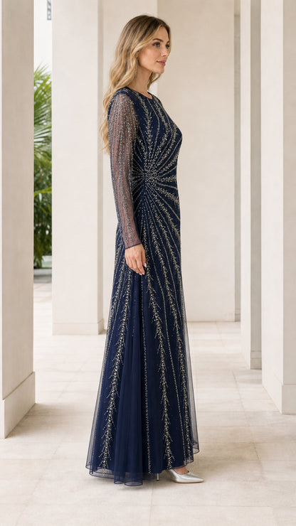 Side view of woman in navy blue floor-length embellished evening dress