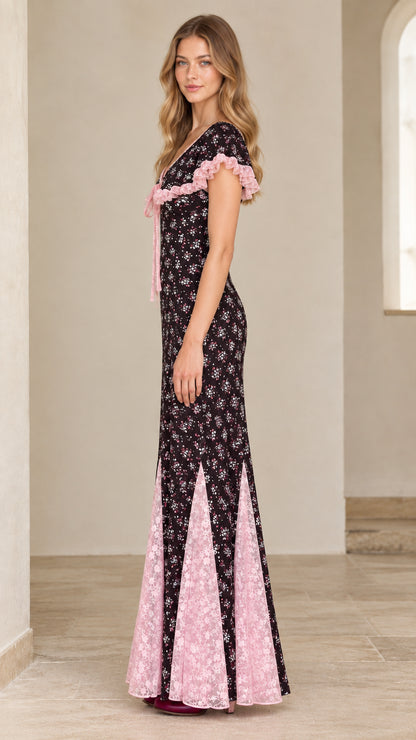 Side profile view of black floral godet maxi dress showing lace trim
