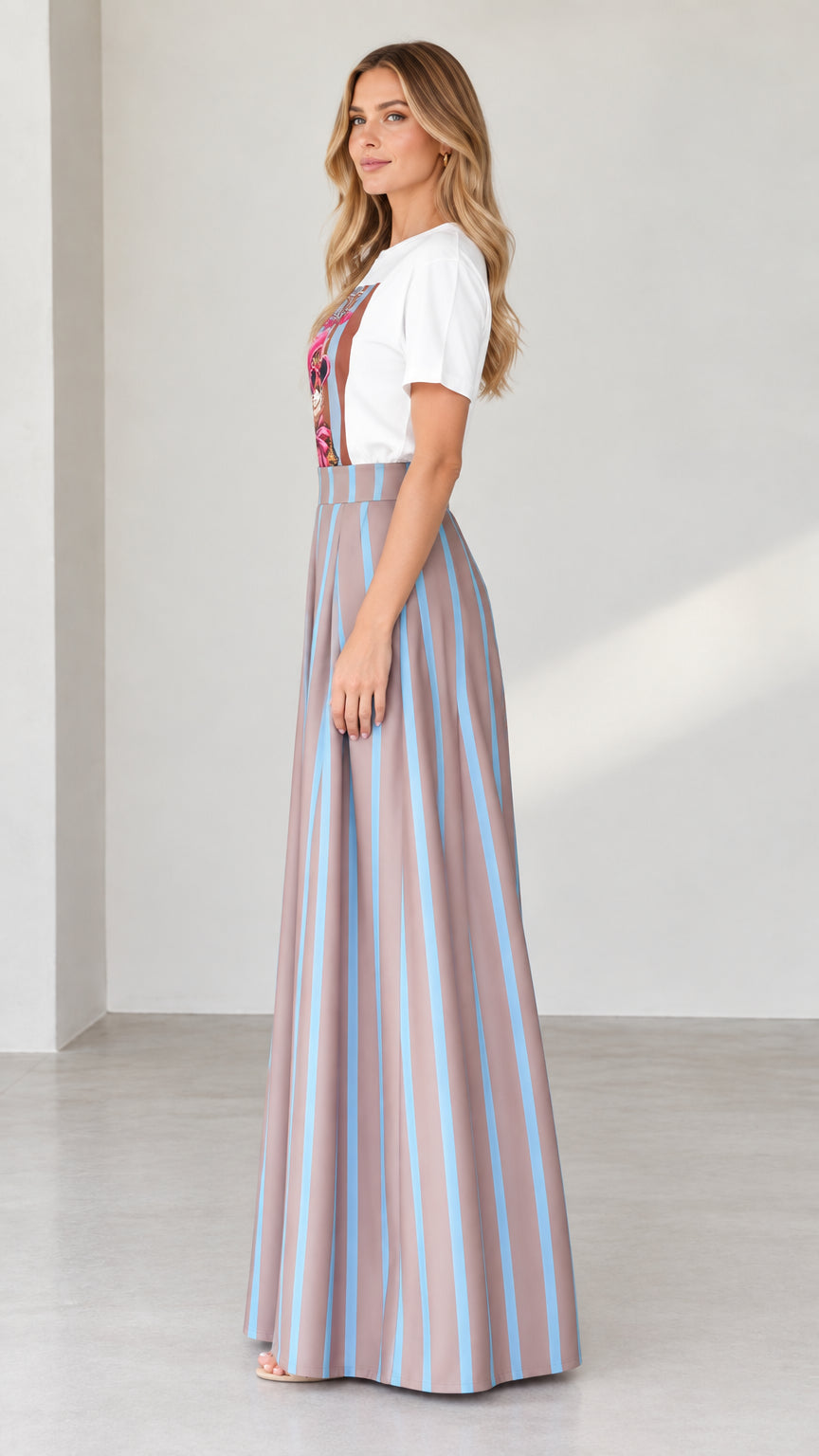 Side profile of woman in graphic t-shirt and pleated striped palazzo pants in mocha