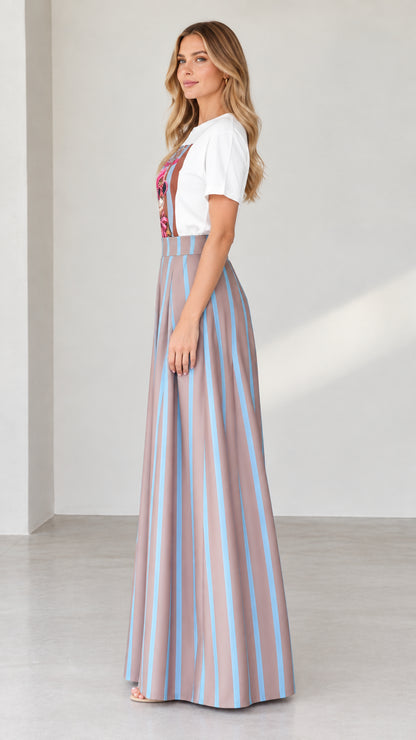 Side profile of woman in graphic t-shirt and pleated striped palazzo pants in mocha